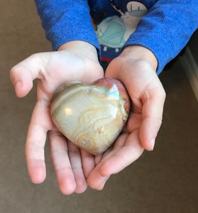 Child holding heart shaped stone